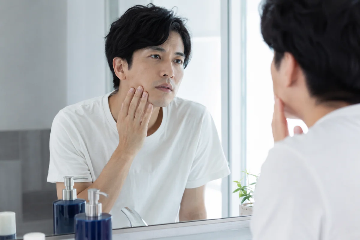 ハイドラフェイシャルで扱える肌の悩みを鏡で確認する30代男性